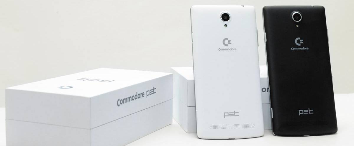 Two modern Commodore-branded smartphones resting against a cardboard box.
