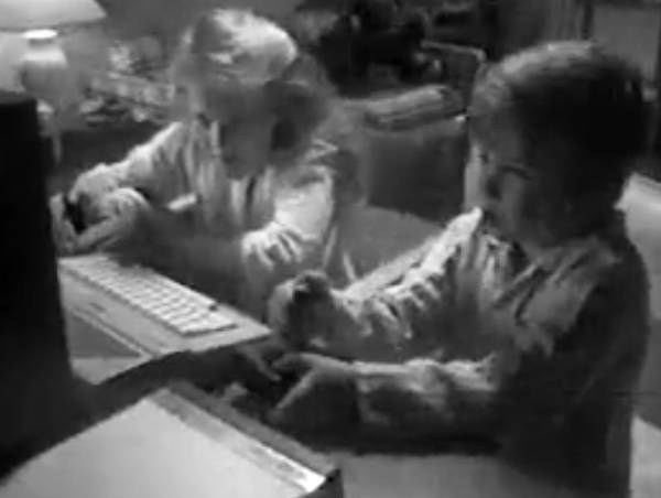 A young girl and boy playing games on an Atari computer.